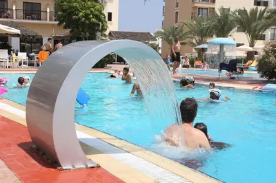 a group of people playing in a swimming pool at Tsokkos Gardens Hotel in Protaras
