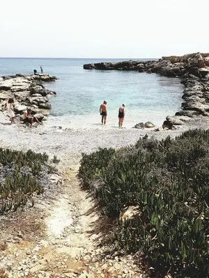 a group of people walking on a beach at Odessa Beach Hotel in Protaras