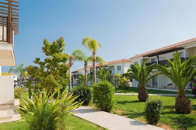 a resort with palm trees and a building at Tsokkos Paradise Holiday Village in Ayia Napa