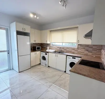 a kitchen with a white refrigerator and a dishwasher at Melia Suites in Limassol