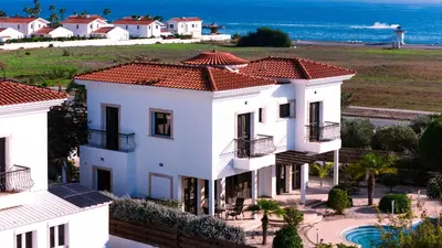 a white house with a view of the ocean at Beachfront Villa with Private Pool and Exotic Fruit Garden in Pyla