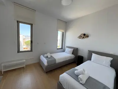 a bedroom with two beds and a window at WealthyStays Parkside Residence in Nicosia