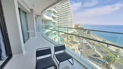 a balcony with two chairs and a view of a building at Del Mar 2 bedroom Seaside 'A' Residence in Limassol