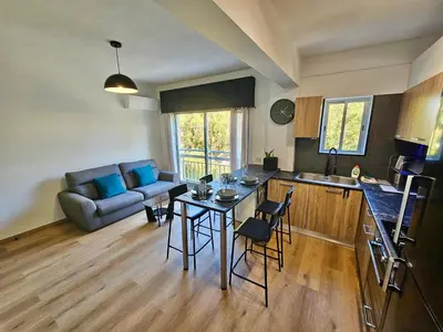 a kitchen and living room with a table and a couch at Central Riverside Escape Charming 1- Bedroom Flat in Limassol