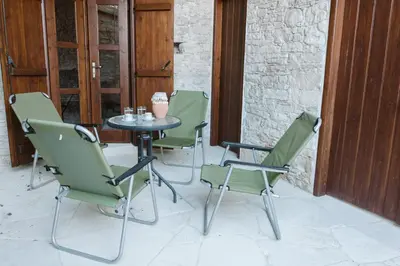 a table and four chairs on a patio at Ariadni Cottage in Vasa