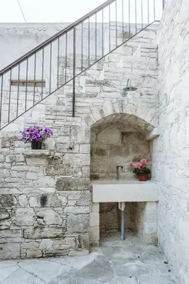 a stone wall with a sink and a staircase at Ariadni Cottage in Vasa