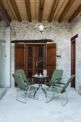 a patio with a table and four chairs at Ariadni Cottage in Vasa
