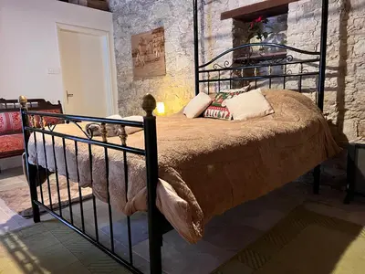 a bedroom with a large bed with a metal frame at Ariadni Cottage in Vasa
