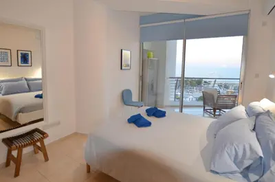 a bedroom with a bed and a view of the ocean at Awesome Sea & Marina View City Center 1 Bdr Flat in Larnaka