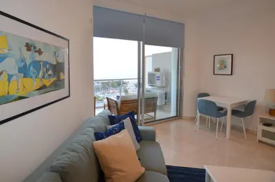 a living room with a couch and a table at Awesome Sea & Marina View City Center 1 Bdr Flat in Larnaka