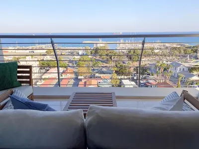 a balcony with a couch and a view of a city at Awesome Sea & Marina View City Center 1 Bdr Flat in Larnaka