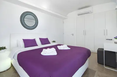 a bedroom with a purple bed with a mirror at Apartment Josephine - Beachfront in Protaras