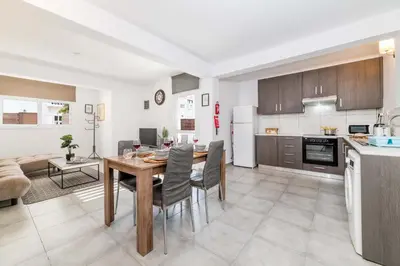 a kitchen and living room with a table and chairs at Napa Centro Apartment in Ayia Napa