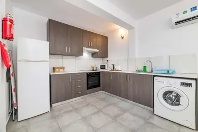 a kitchen with a white refrigerator and a washing machine at Napa Centro Apartment in Ayia Napa