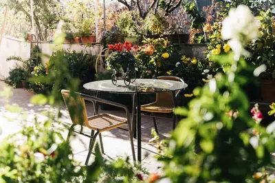 a table and chairs in a garden with flowers at Kyperounta Retreat in Kyperounda