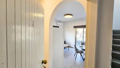 a hallway with a door leading to a dining room at La Magenta Apartments in Pyla
