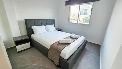 a small bedroom with a bed and a window at La Magenta Apartments in Pyla