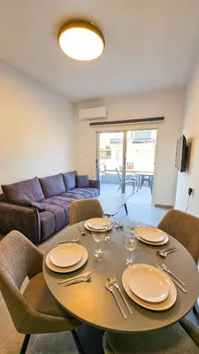 a living room with a table with plates and wine glasses at La Magenta Apartments in Pyla