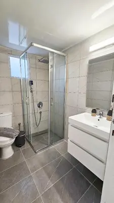 a bathroom with a shower and a toilet and a sink at La Magenta Apartments in Pyla