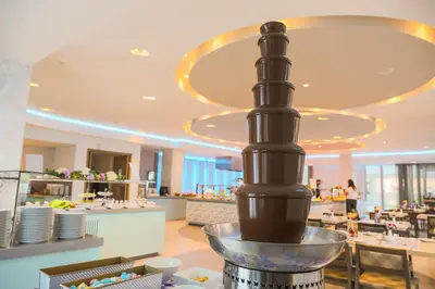 a restaurant with a pole in the middle of a room at Vassos Nissi Plage Hotel & Spa in Ayia Napa