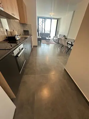 a kitchen and living room with a table and chairs at Luxurious two bedroom apartment with roof garden in Kato Lakatamia
