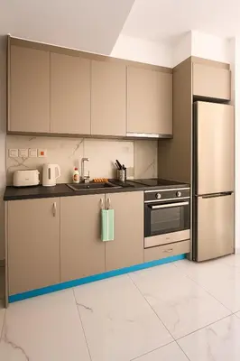 a kitchen with stainless steel appliances and white tile floors at Limassol Centr Apartament in Limassol