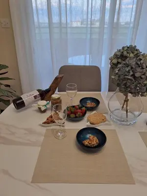 a table with a bottle of wine and plates of food at Blue Boutique Flat in Larnaka