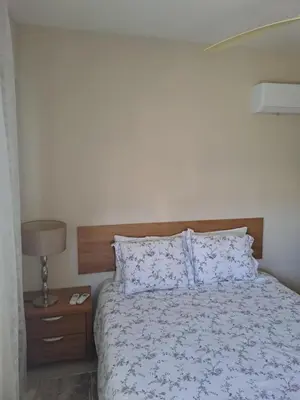 a bedroom with a bed and a night stand with a lamp at Blue Boutique Flat in Larnaka