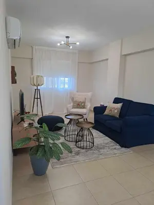 a living room with a blue couch and a table at Blue Boutique Flat in Larnaka