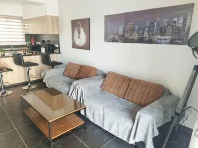 a living room with a couch and a table at Mackenzie Suite in Larnaka