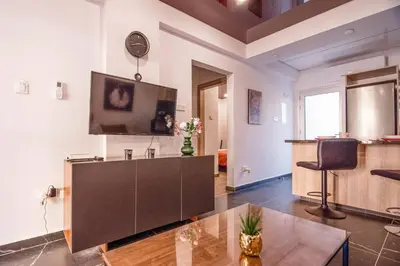 a living room with a tv and a table at Mackenzie Suite in Larnaka