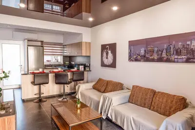 a living room with a couch and a kitchen at Mackenzie Suite in Larnaka