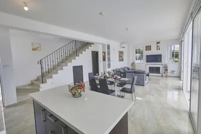 a kitchen and living room with a table and chairs at Protaras Pearl Villa Pe15 in Protaras