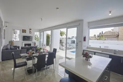 a kitchen and living room with a table and chairs at Protaras Pearl Villa Pe15 in Protaras