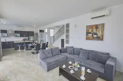 a living room with a gray couch and a table at Protaras Pearl Villa Pe15 in Protaras