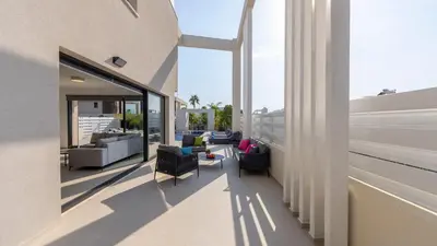 a balcony with chairs and couches on a building at Nissi Residences Villa 4 in Ayia Napa