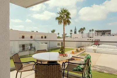 a patio with a table and chairs on a balcony at SUNWING Sandy Bay Beach Village in Ayia Napa