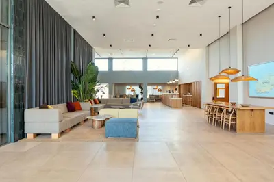a lobby with couches and chairs and a table at SUNWING Sandy Bay Beach Village in Ayia Napa
