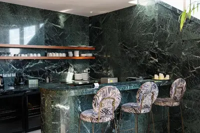a restaurant with a black marble counter and chairs at 360 Sky Residence, Gym & Pool - 26th Floor in Nicosia
