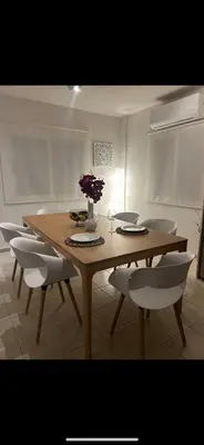 a dining room table with chairs and a table with flowers on it at Gardens Villa in Ayia Napa