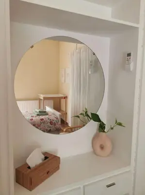 a mirror in a white room with a bedroom at Cozy Family Home in Laxia