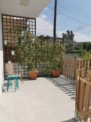 a patio with a chair and potted plants and a fence at Cozy Family Home in Laxia