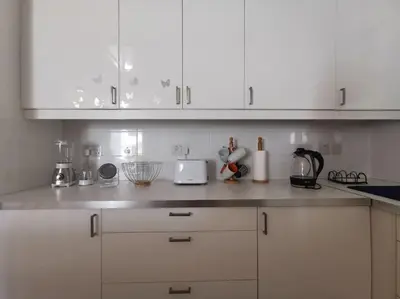 a white kitchen with white cabinets and appliances at Cozy Family Home in Laxia