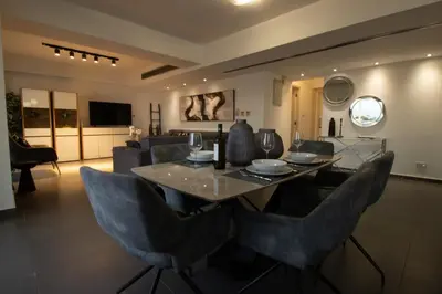 a dining room and living room with a table and chairs at Top Floor Gem: 3BR, Huge Veranda in Nicosia