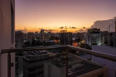 a view of a city at sunset from a balcony at Top Floor Gem: 3BR, Huge Veranda in Nicosia