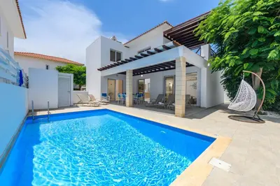 a swimming pool in front of a house at Konnos Breeze Villa in Protaras