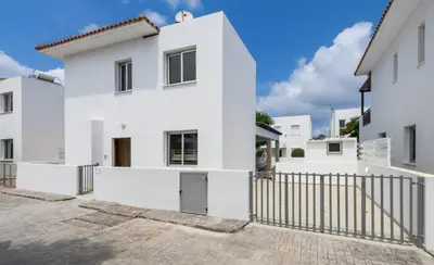 a white house with a gate in front of it at Konnos Breeze Villa in Protaras
