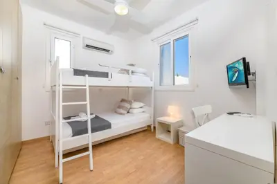 a bedroom with two bunk beds and a desk at Villa Atlantis in Protaras
