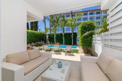 a patio with white furniture and a building at Villa Atlantis in Protaras