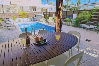 a table with two glasses of wine and a bowl of fruit at Casa Palmera in Paralimni